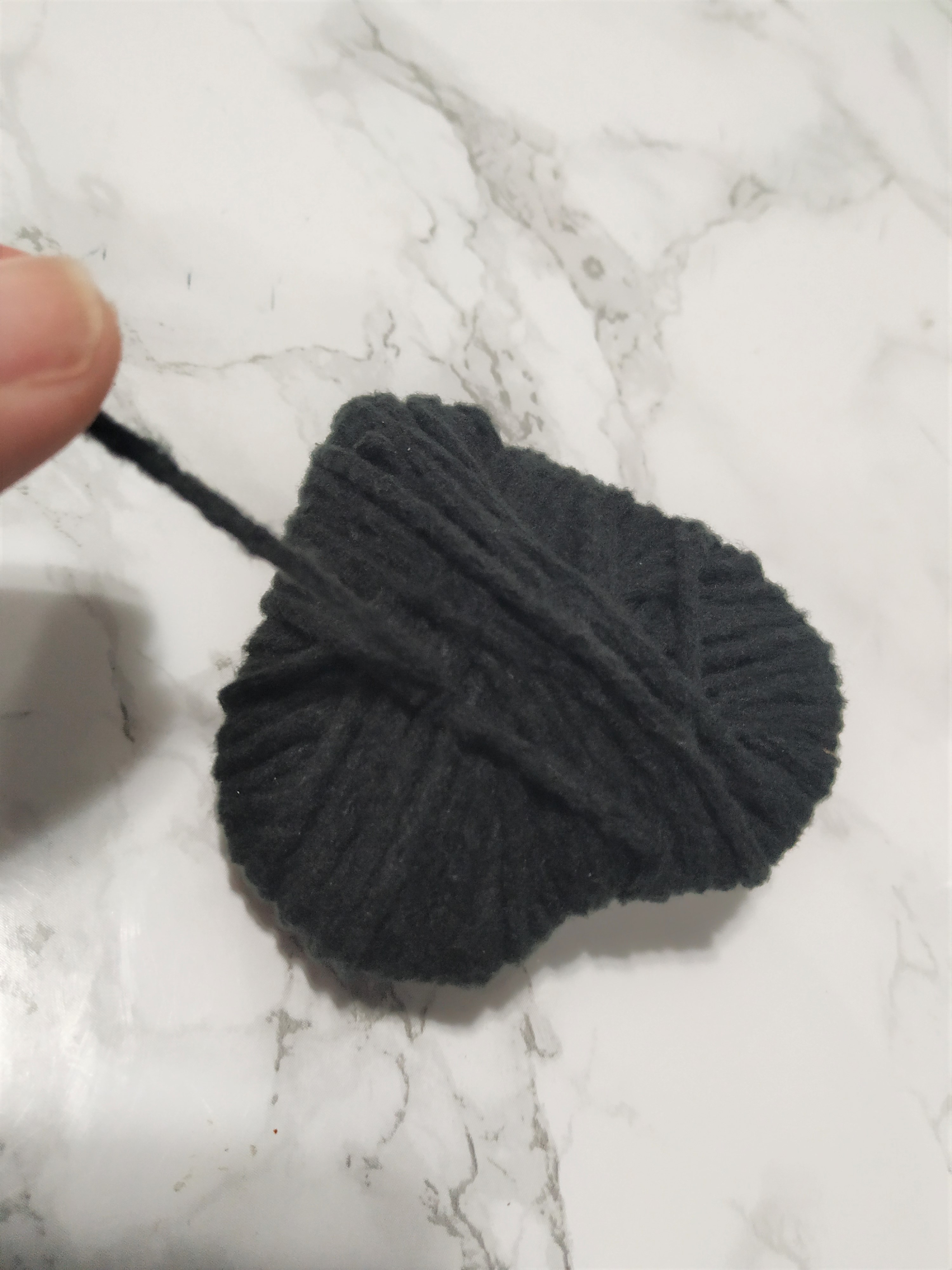 Holding an excess piece of yarn.