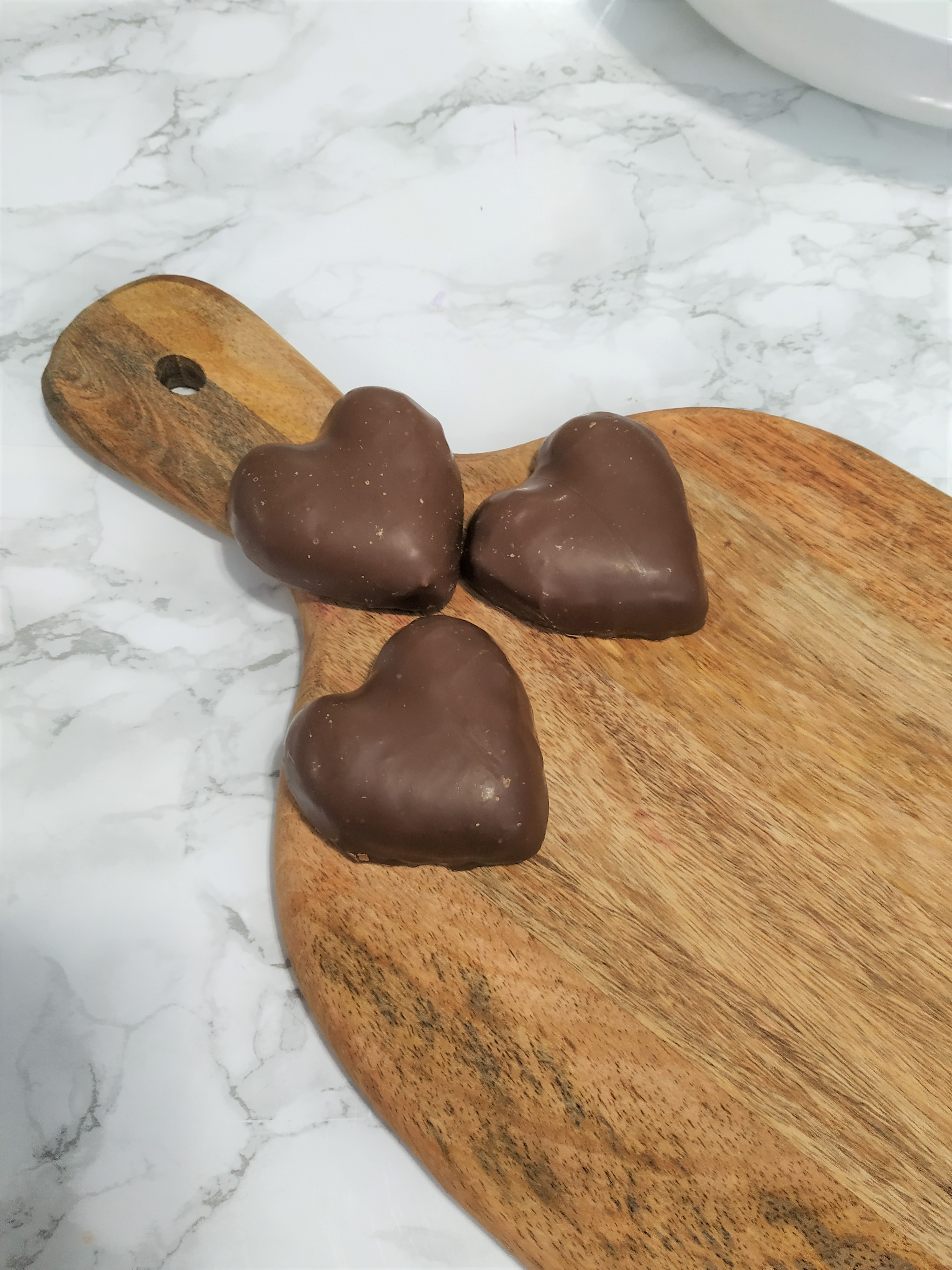 Placing chocolate hearts on the charcuterie board.