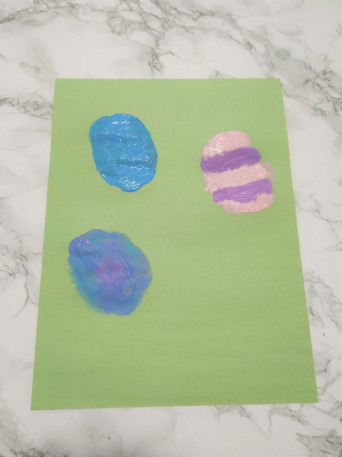 Easter egg stamps on a green piece of paper.