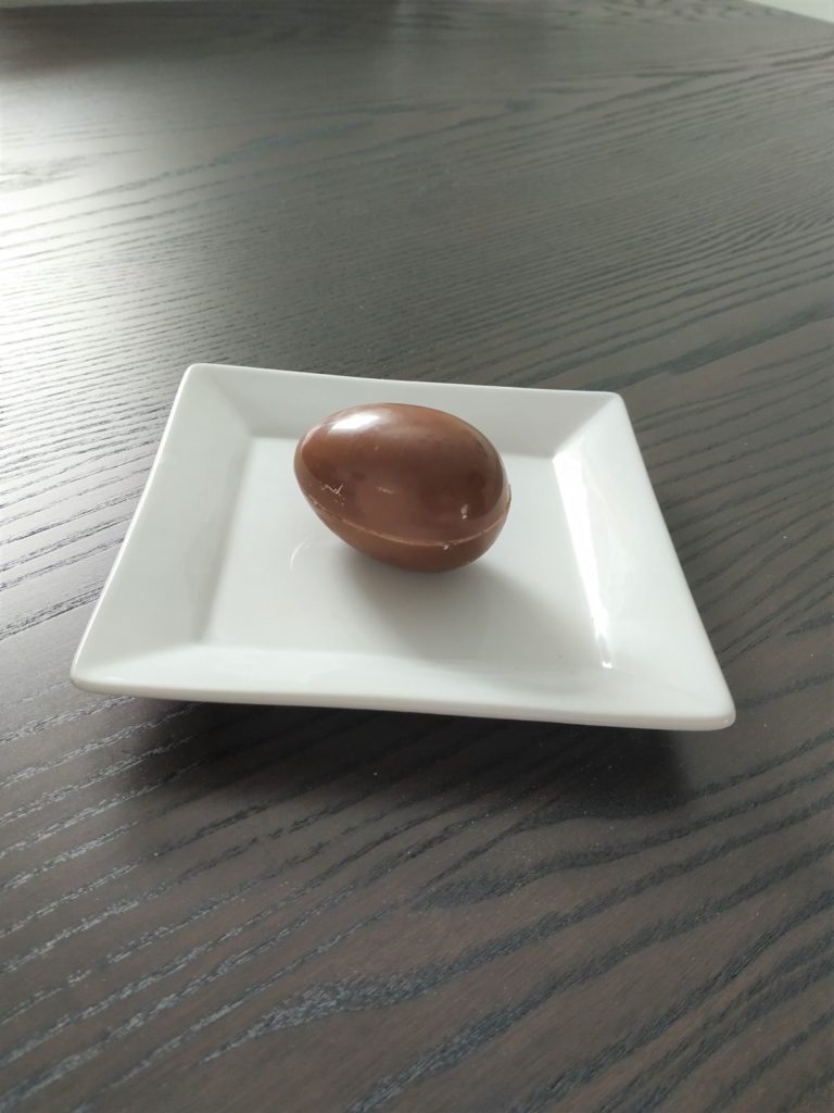 Finished hot chocolate bomb on a white plate.