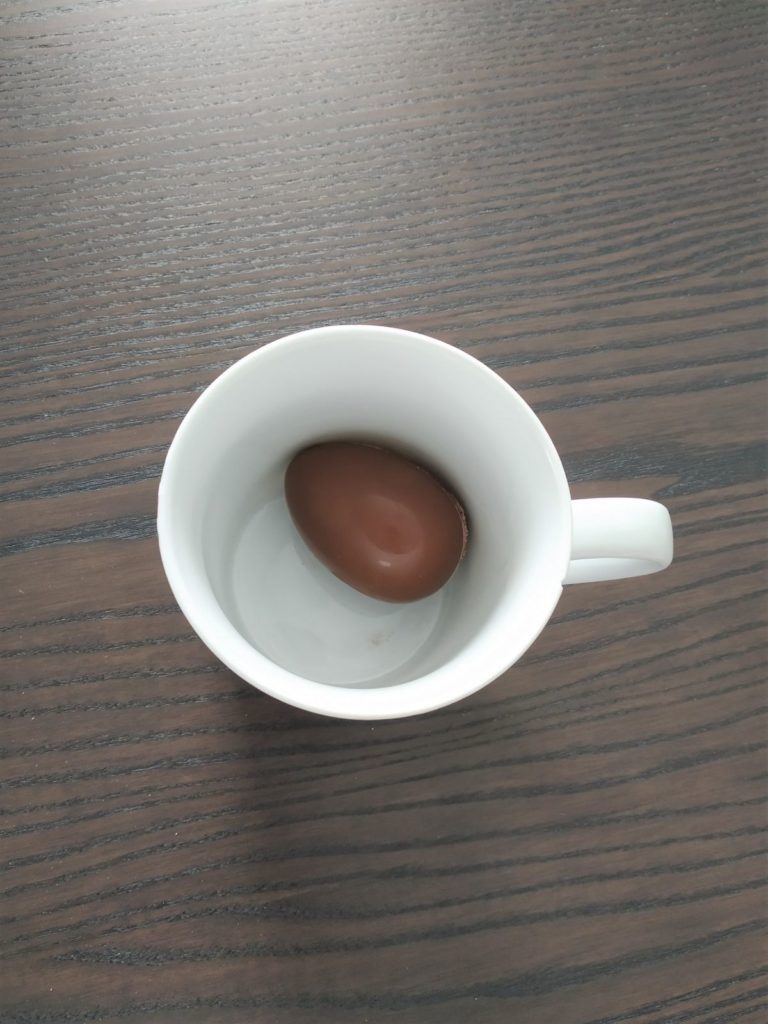 Placing the hot chocolate bomb in a mug.