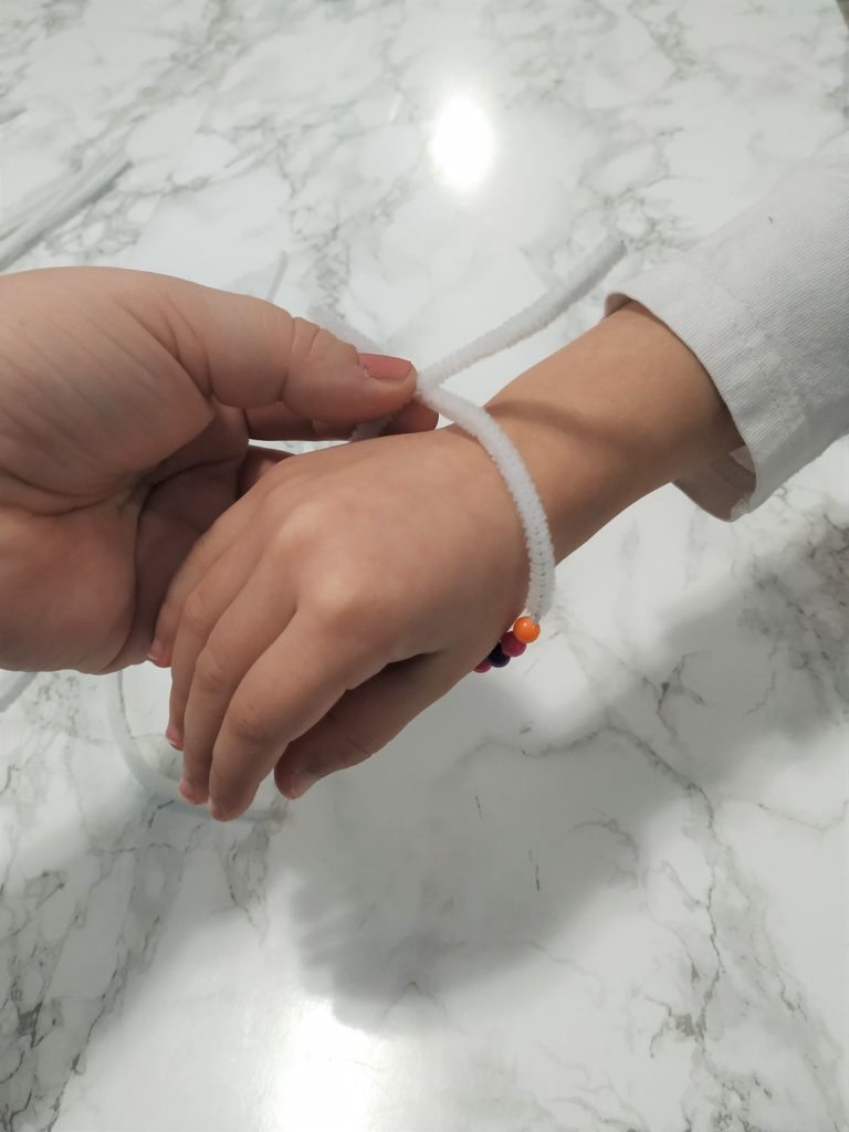 Twisting the ends of the pipe cleaner to form a bracelet.