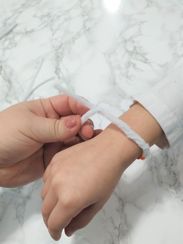 Twisting the ends of the pipe cleaner to form a bracelet.