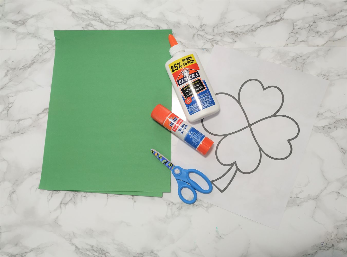 Shamrock coloring page with green paper, scissors and glue.