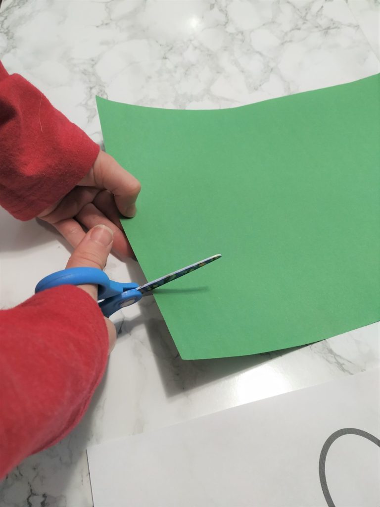 Cutting green paper.