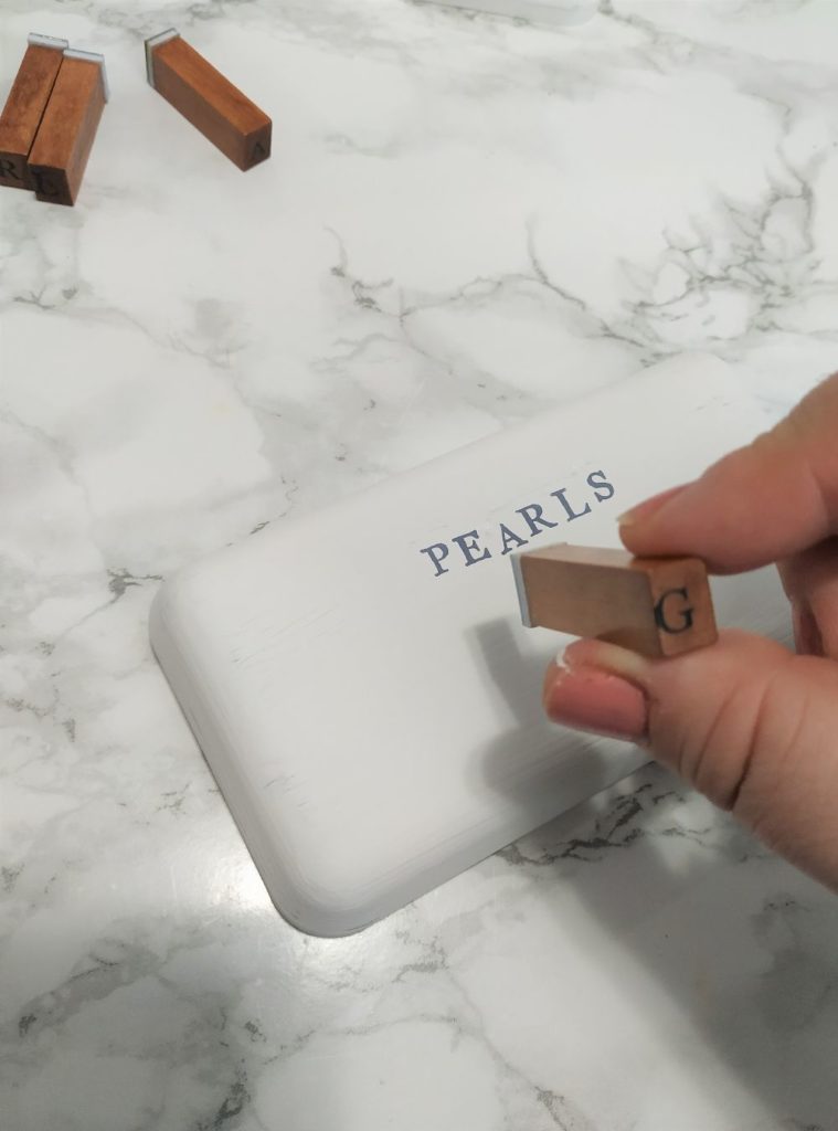 Stamping letters onto the lid of the jewelry box.