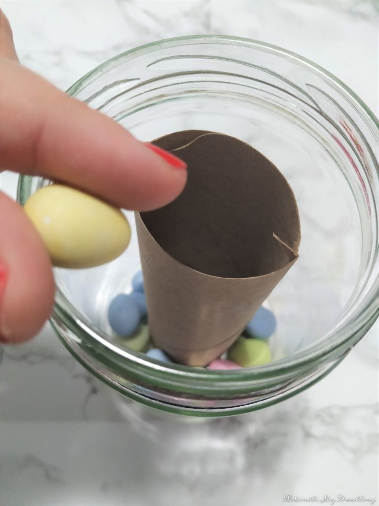Adding a chocoalte egg inside the mason jar.