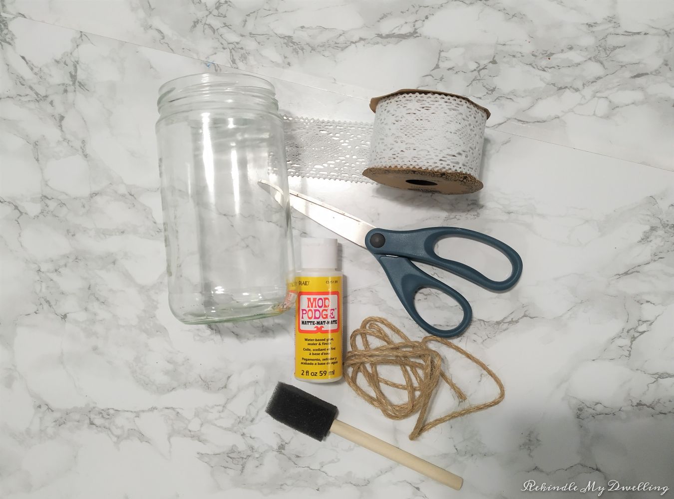 Materials needed to make spring vases including mason jar, ribbon, scissors, twine, mod podge and a paint brush.