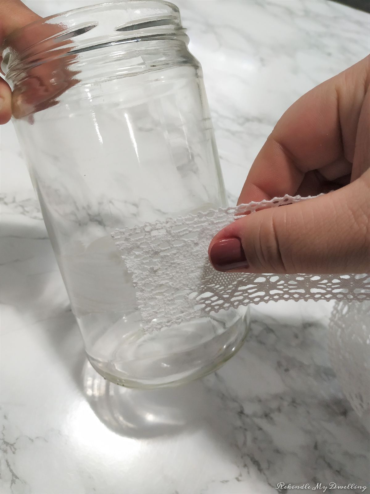 Wrapping lace ribbon around a mason jar.