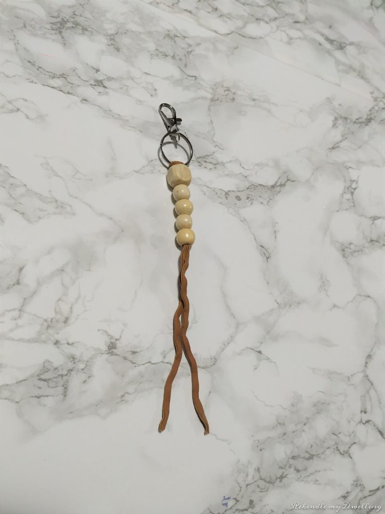 Adding wood beads onto a leather string.