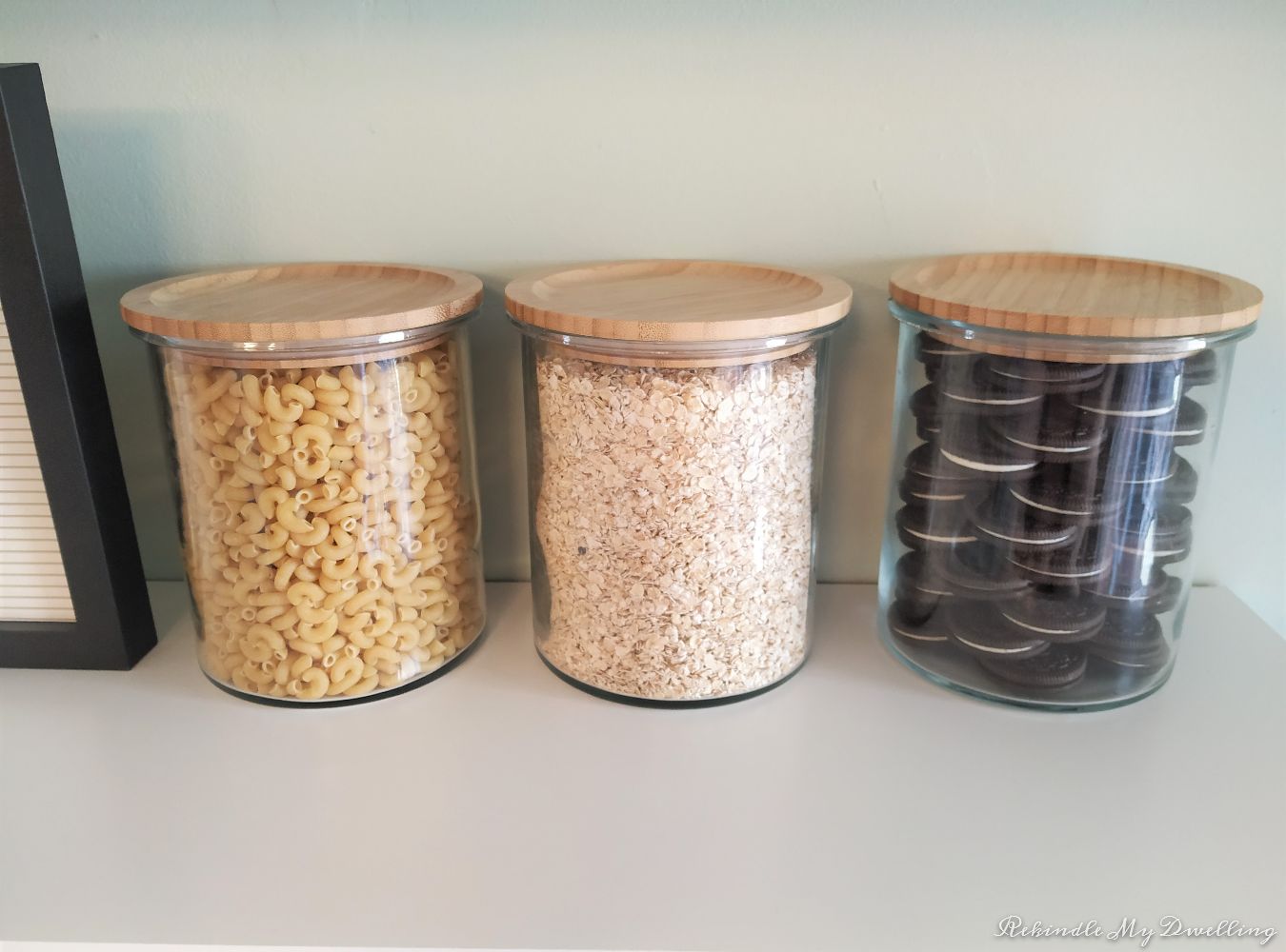 Glass jars filled with macaroni, oats and cookies.
