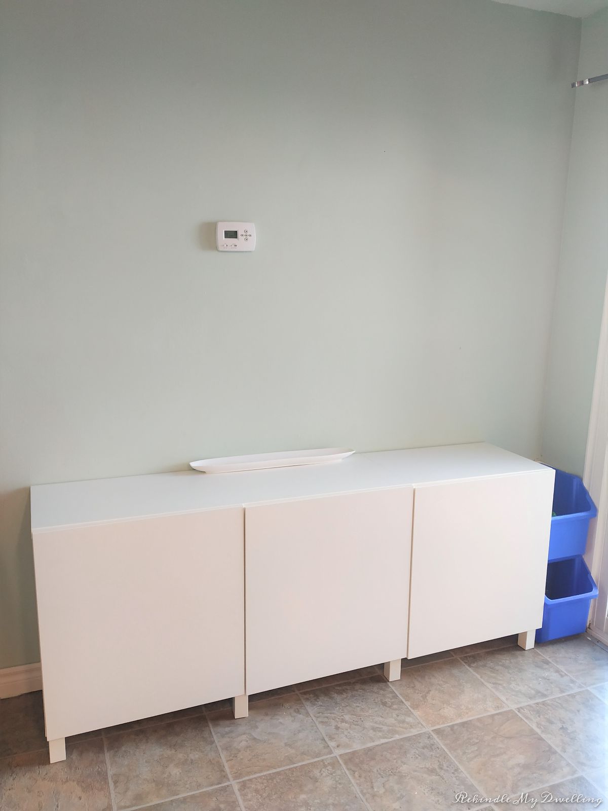 Blank wall with storage sideboard.