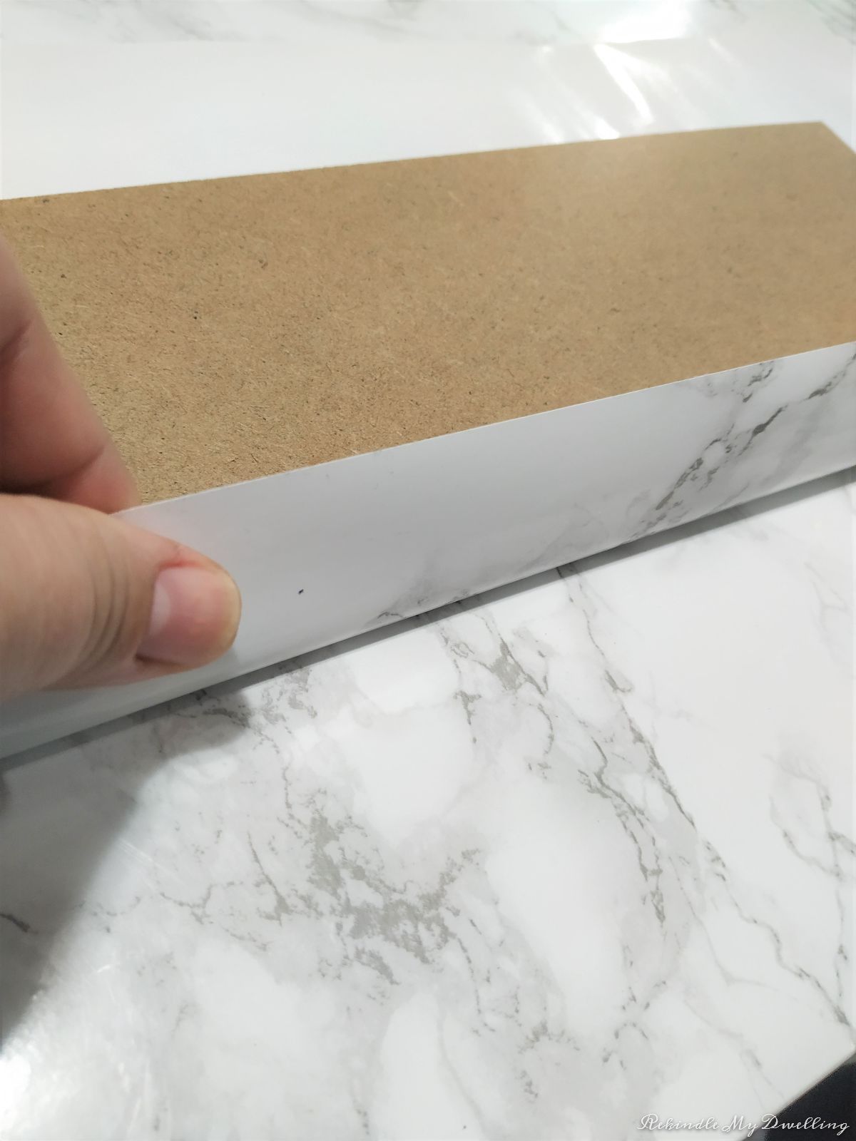 Wrapping marble contact paper around the board.