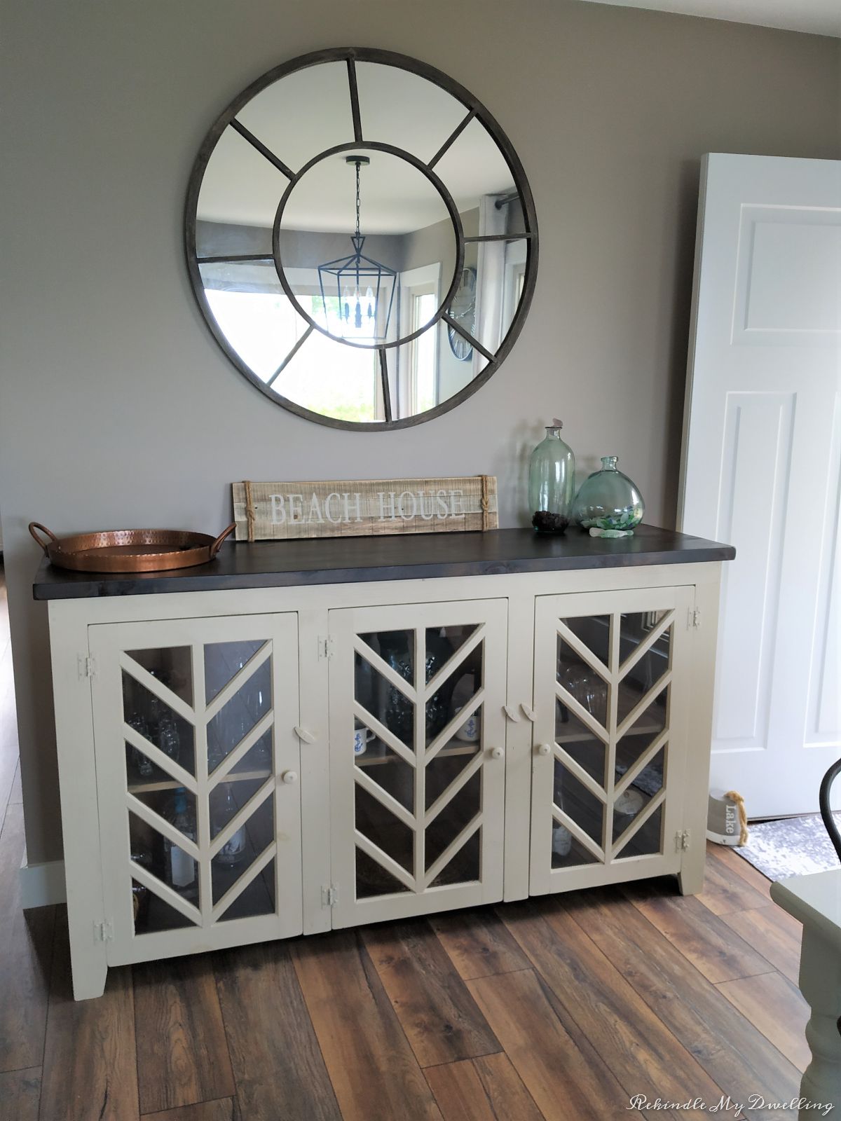 Cottage makeover buffet with large mirror above it.