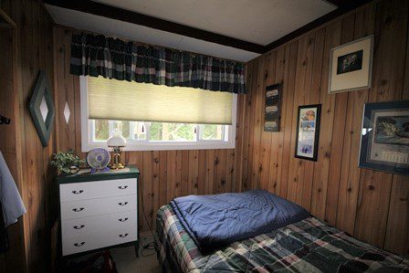 Bedroom with wood paneling.