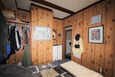 Bedroom with wood paneling.