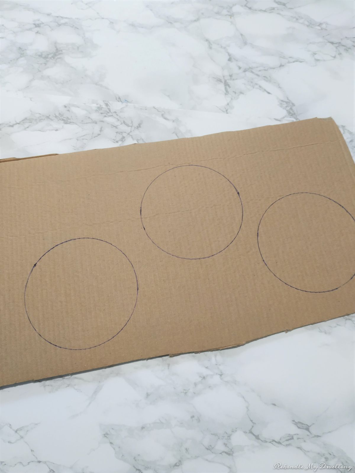 Tracing circles on a piece of cardboard.