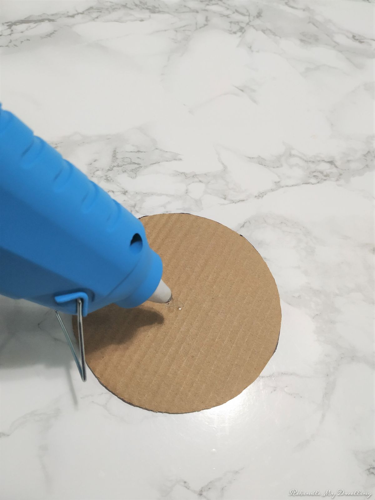 Adding a dab of hot glue to the middle of the circle cut out.