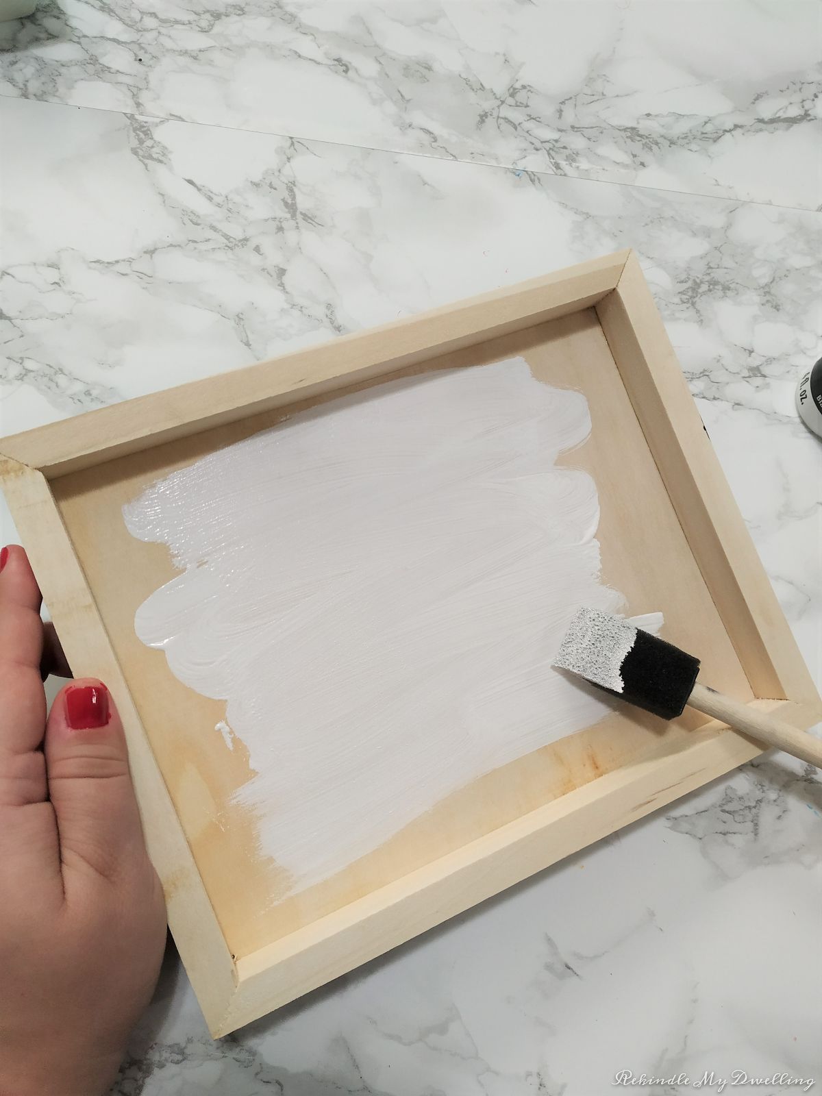 Painting a wood tray white.