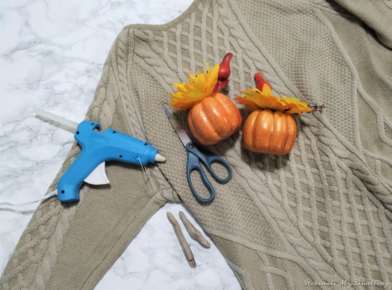 Materials need to make no-sew sweater pumpkins including foam pumpkins, sweater, scissors, driftwood and hot glue.