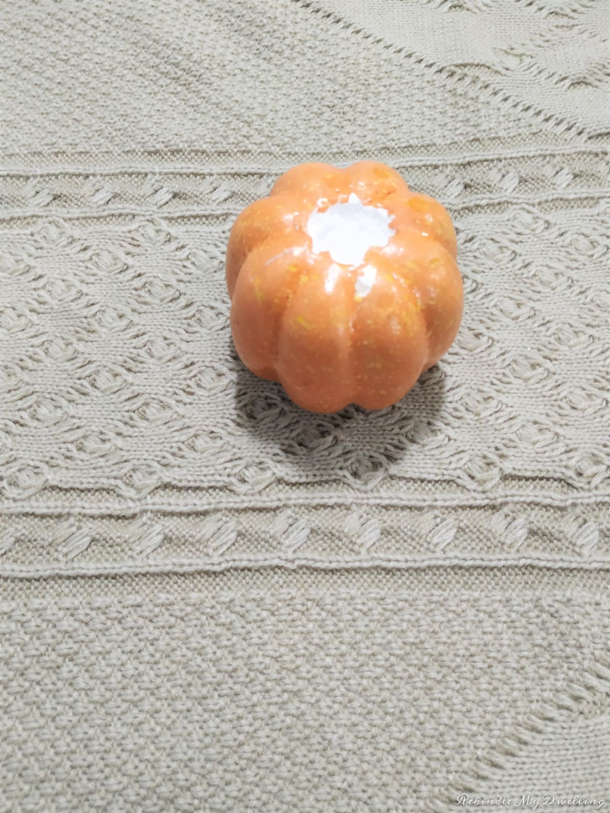 Placing a foam pumpkin on top of a sweater.