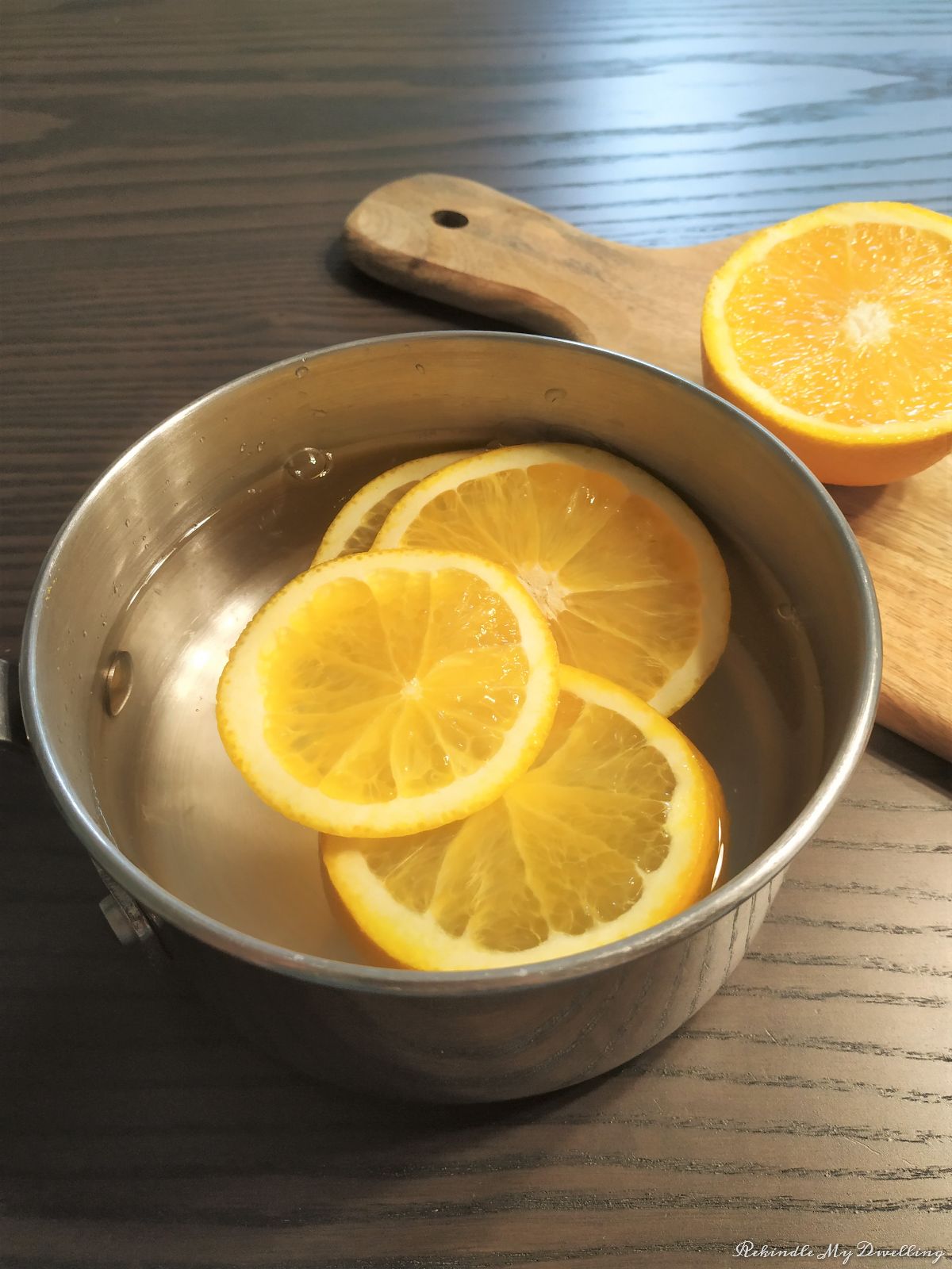 Pot of water with orange slices.