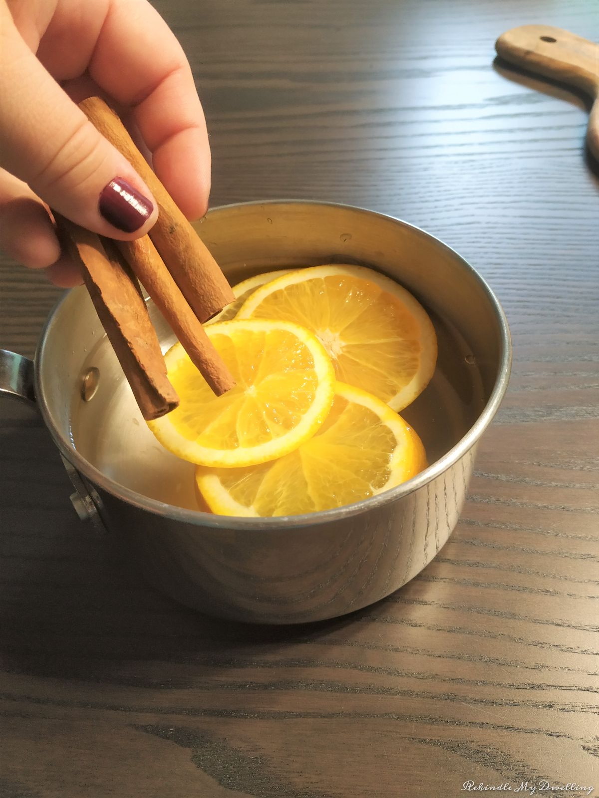 Adding cinnamon sticks into the pot of water.