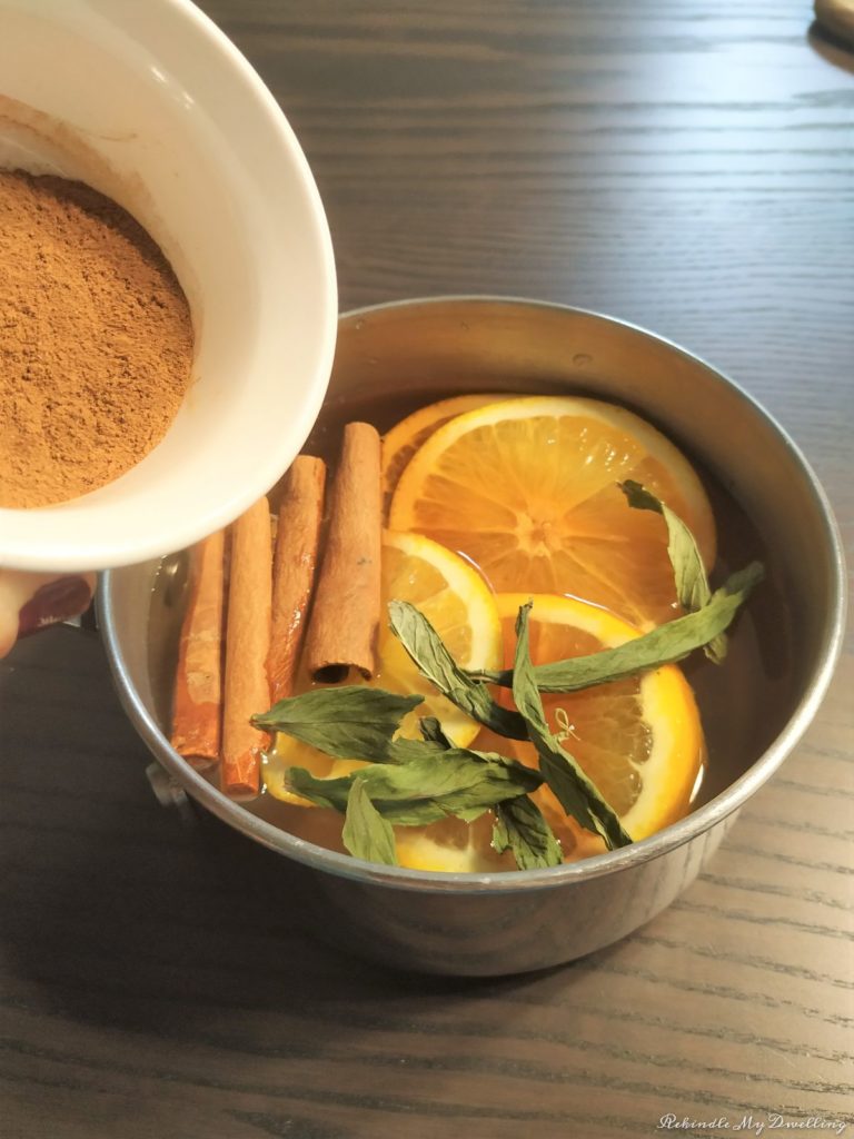 Adding ground cinnamon into the pot of water.