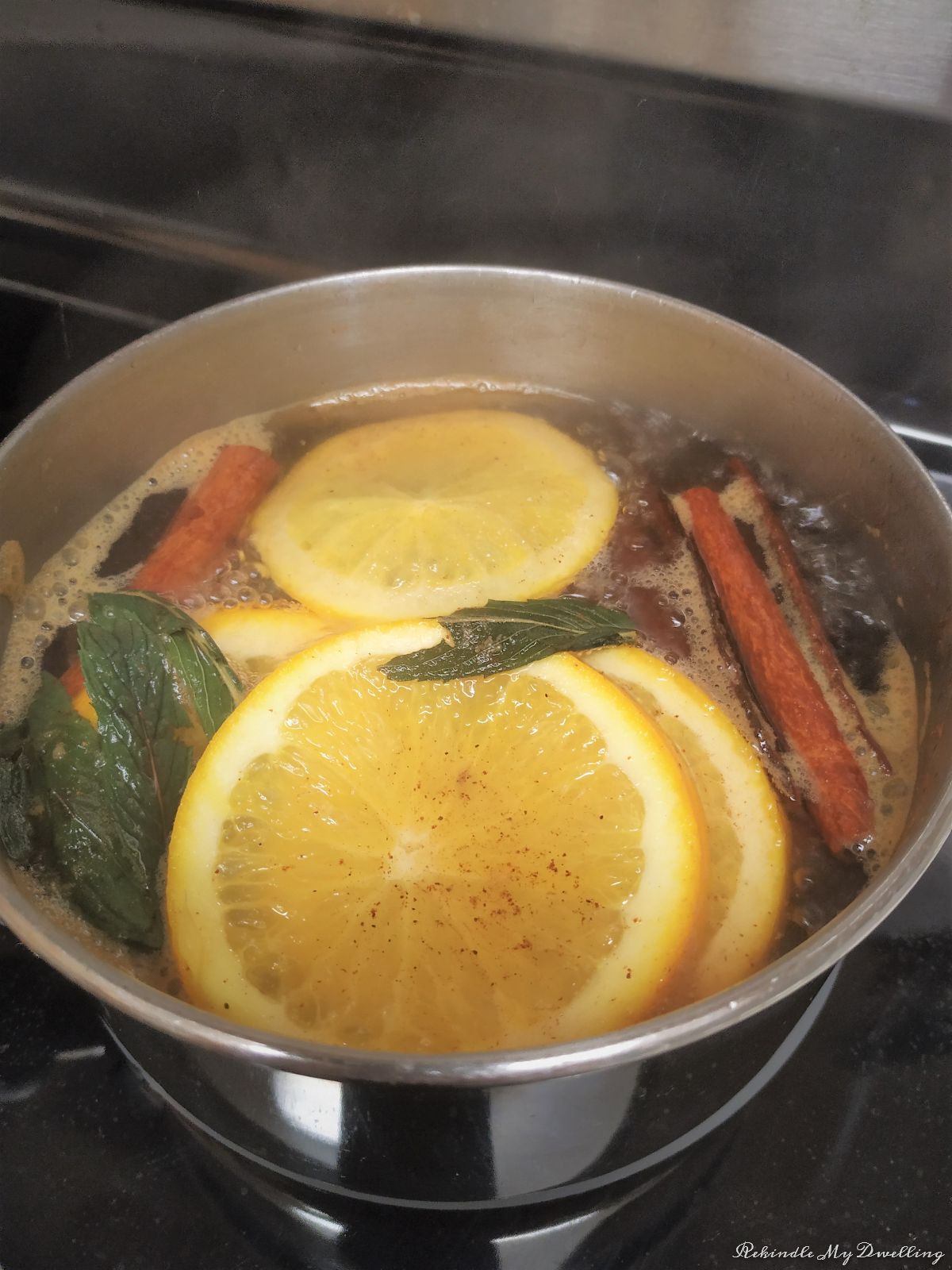 fall simmering pot with orange slices, cinnamon and mint.