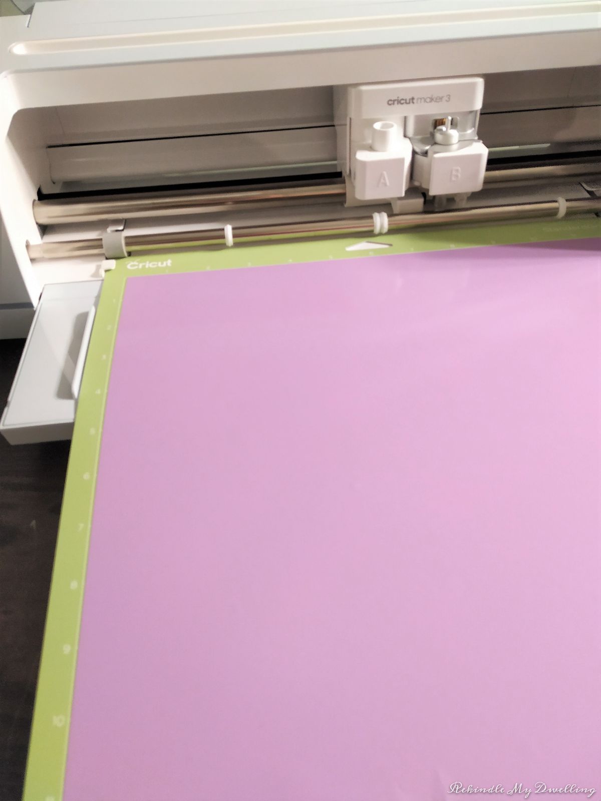 Loading purple vinyl into the Cricut machine.