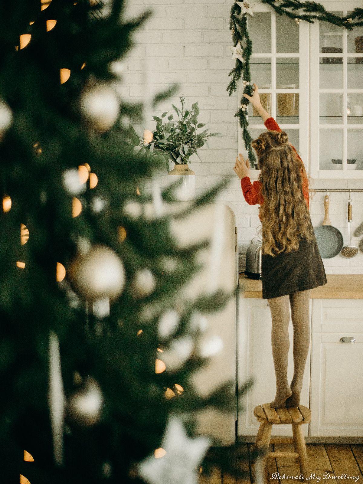 A girl decorating with green garland.