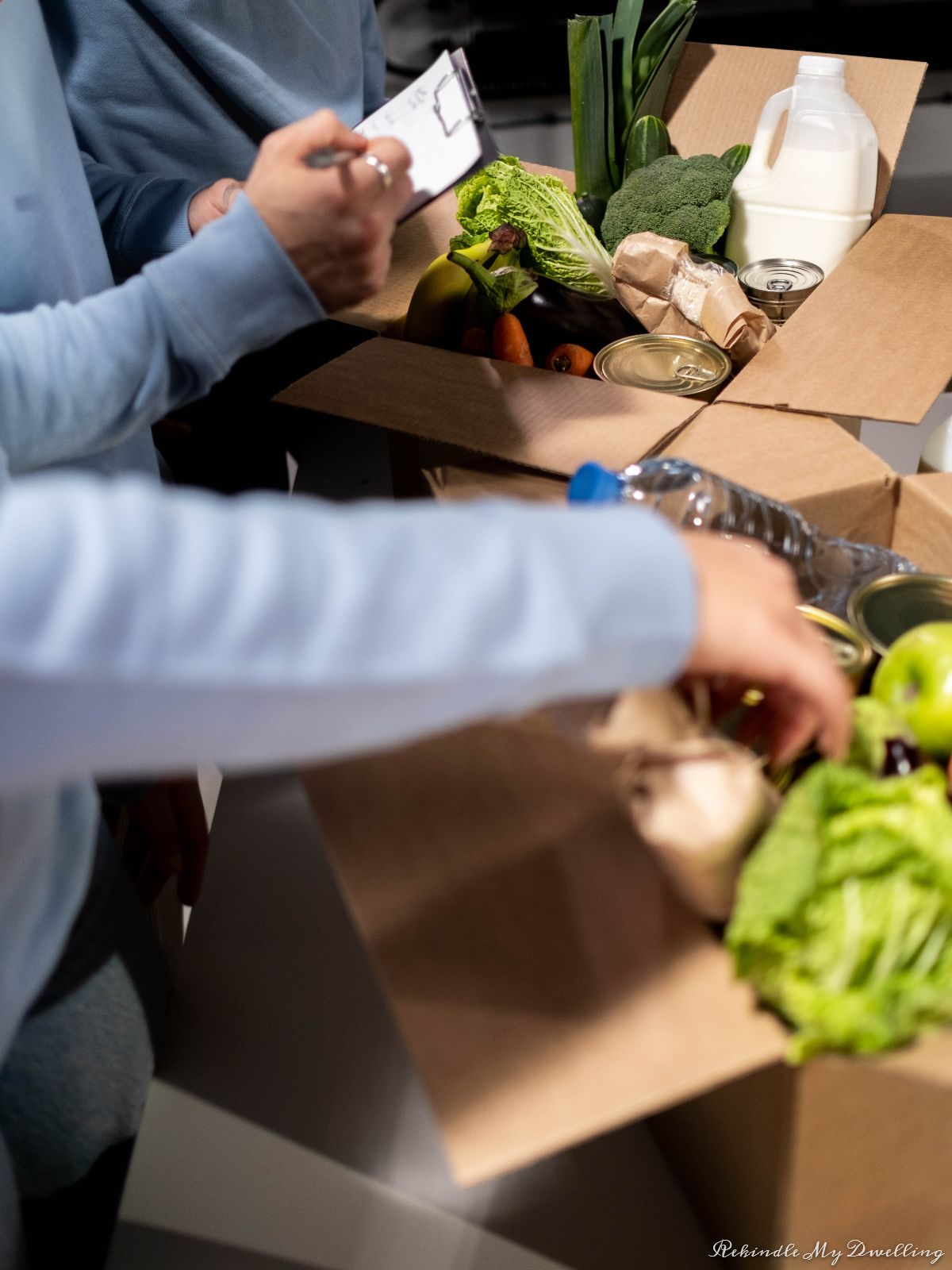 A group of people packing boxes with food.