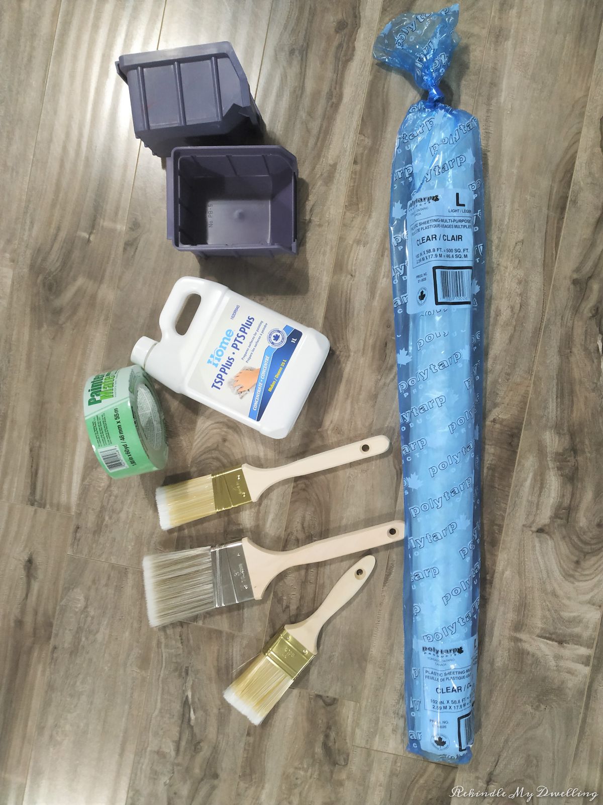 Materials needed for a brick fireplace makeover including paint brushes, tape, cleaner, plastic sheeting.