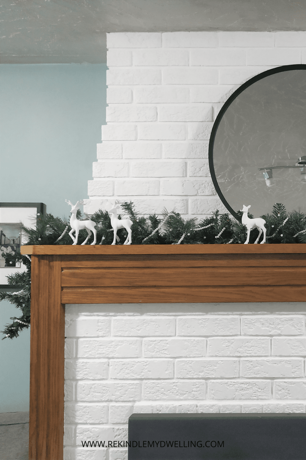 Diy pearl garland on a mantel with decor and a mirror.