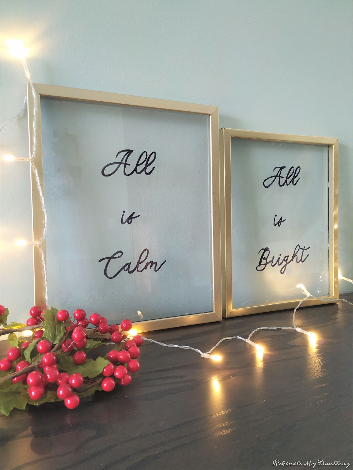 Framed glass floating signs next to lights and holly.