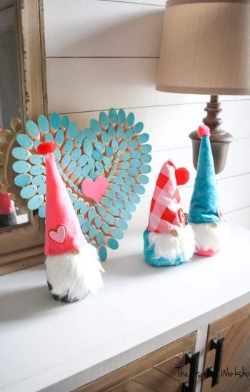 Gnomes next to a wooden heart.