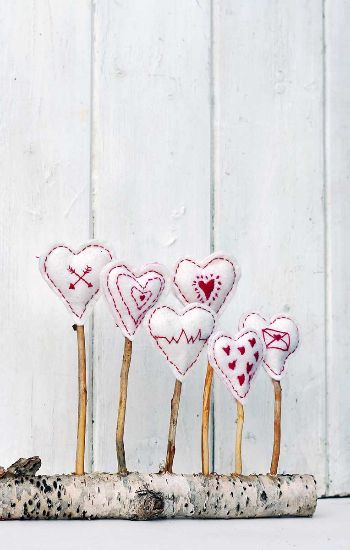 Embroidered hearts attached to sticks.