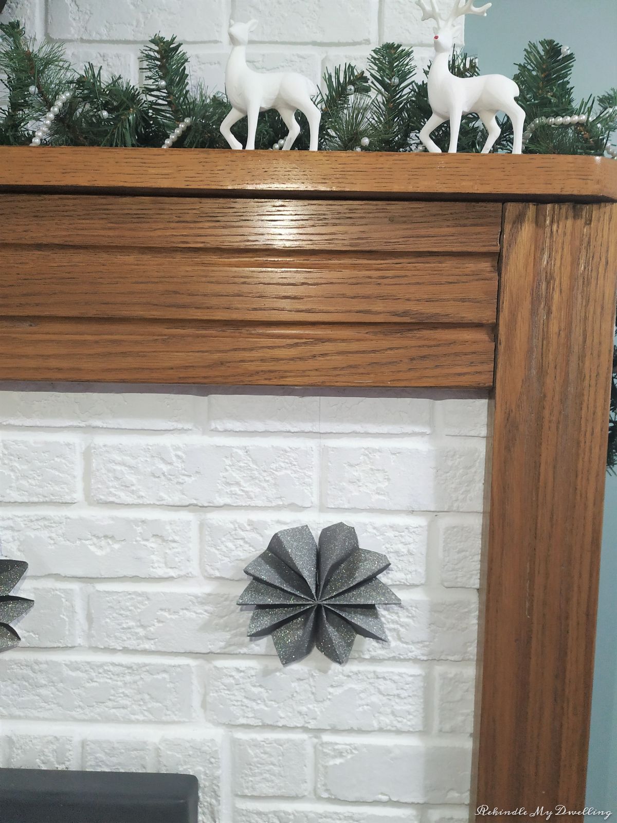 DIY paper stars hung on a fireplace.