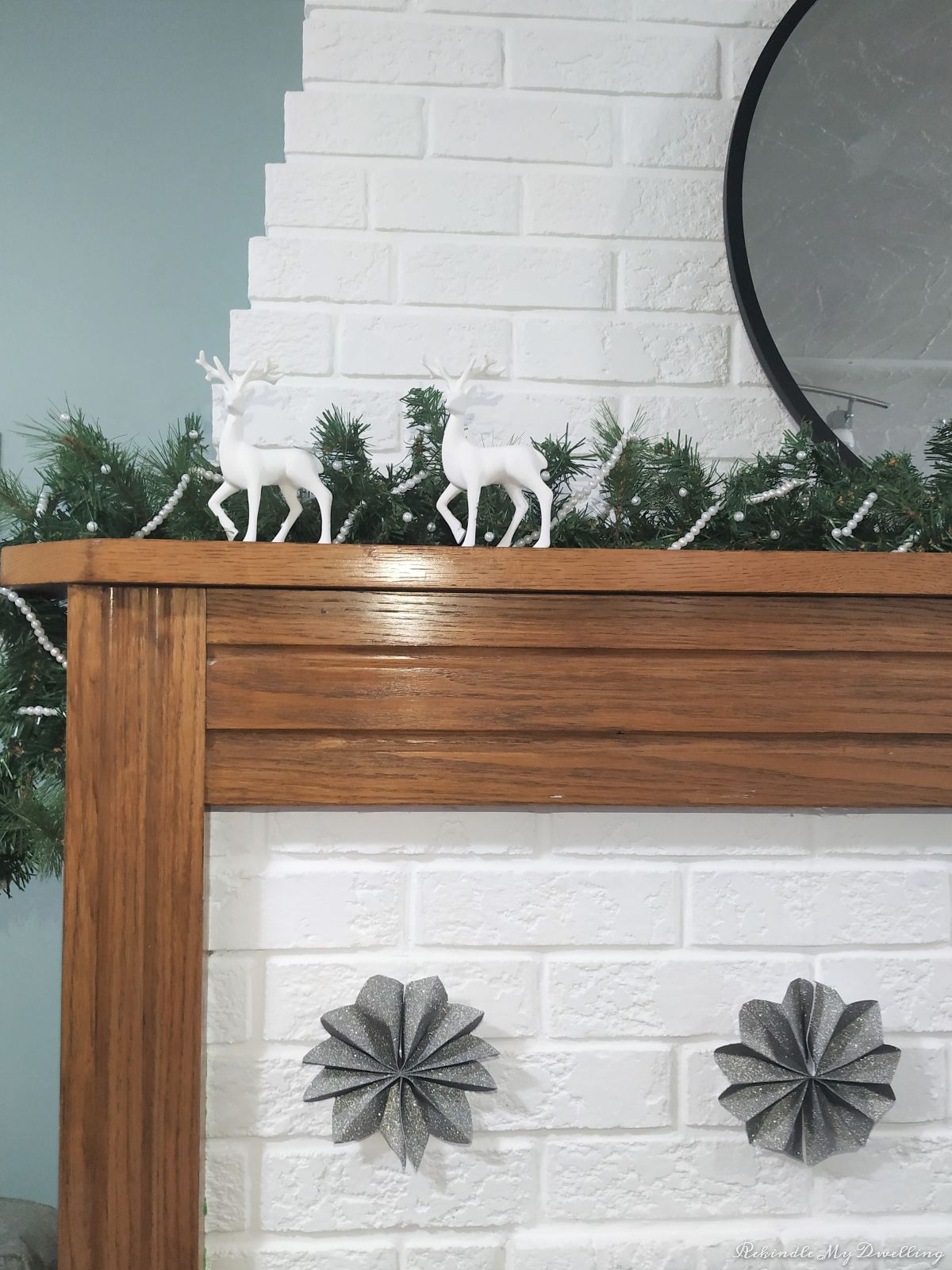 DIY paper stars hung from a fireplace mantel.