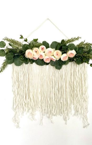 Boho flower hanging with greenery and yarn.