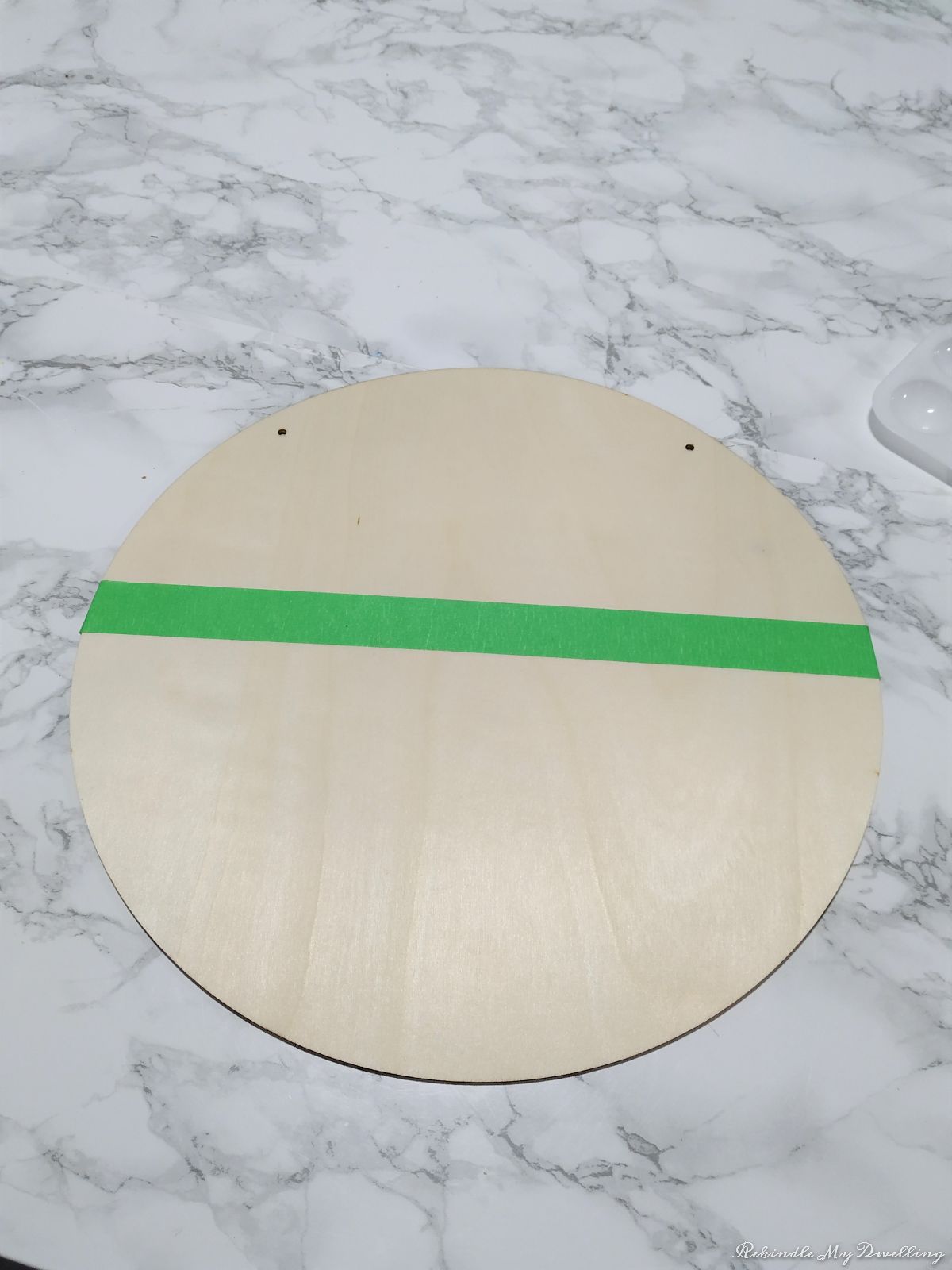 Adding green painters tape to the middle of the wood circle.