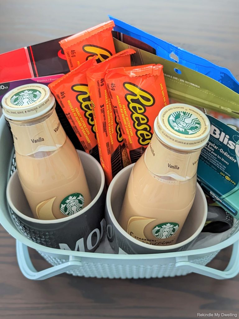 Overhead view of dollar store gift basket idea filled with snacks, coffee, mugs and personal care items.