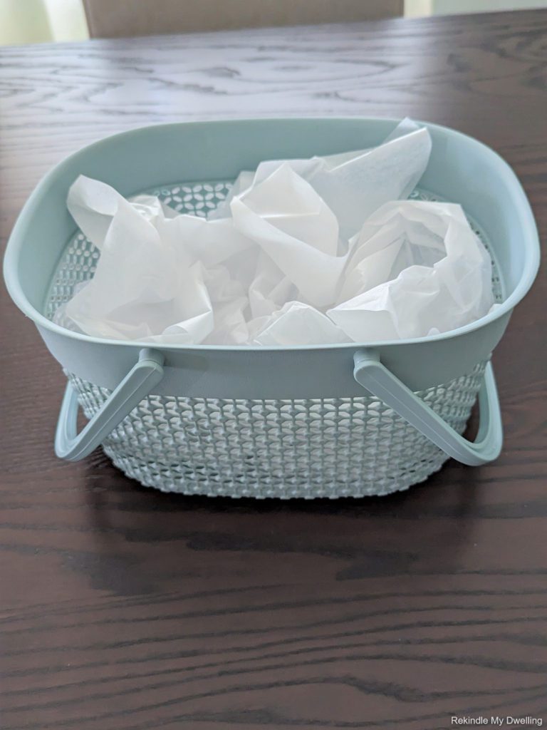 Blue basket filled with tissue paper.