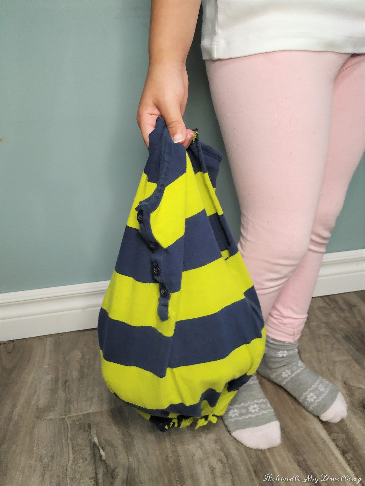 Child holding a no-sew tshirt bag.