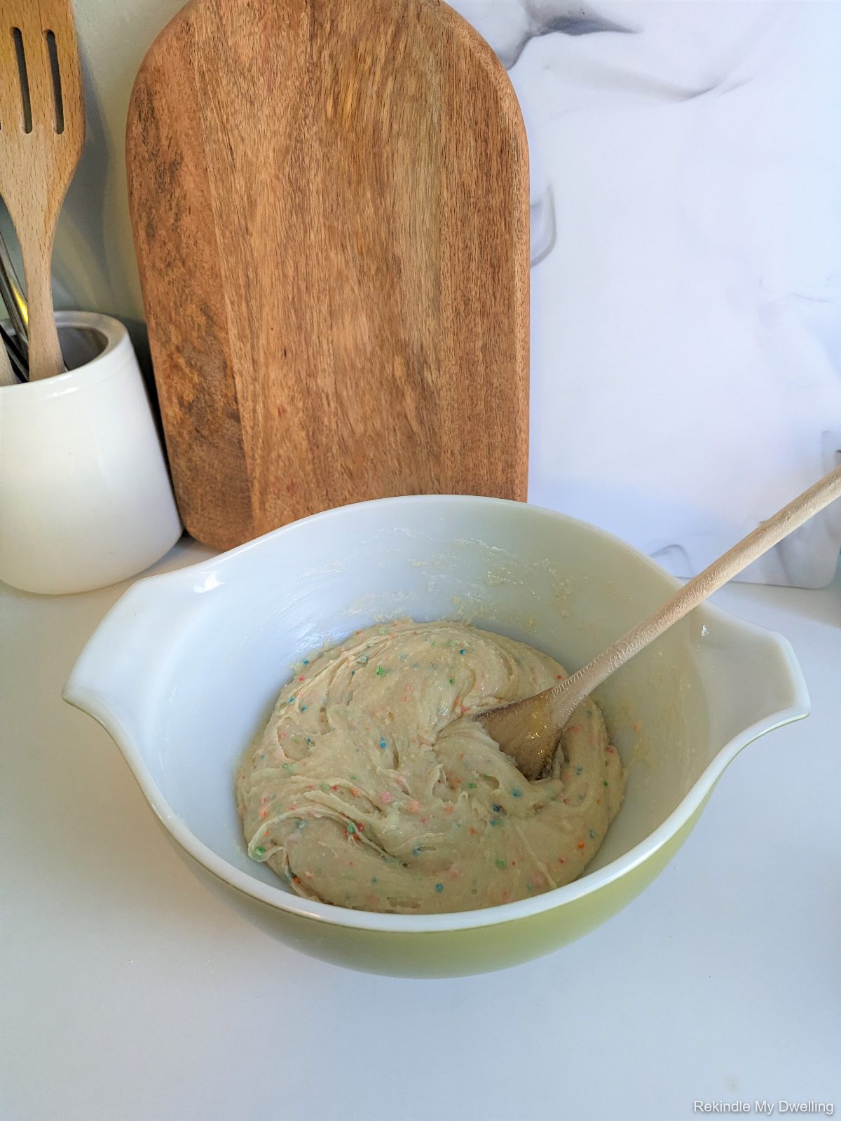 Mixing ingredients in a bowl with a wooden spoon.