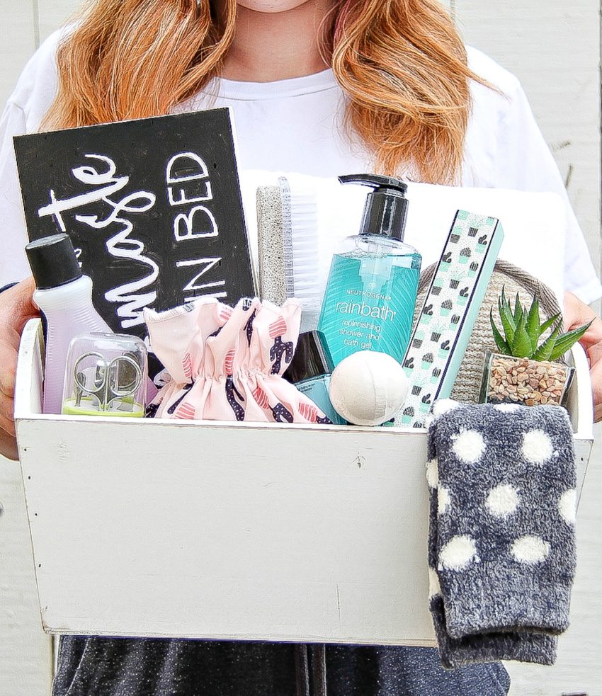 Woman holding a gift basket filled with spa items.