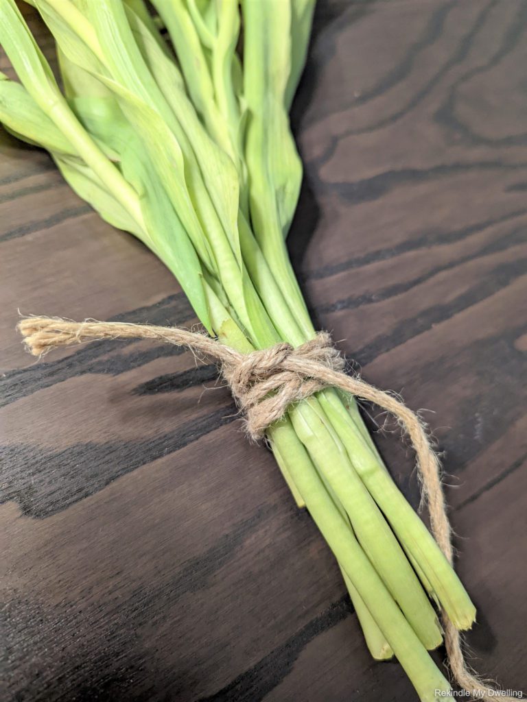 Tying a bunch of flowers together with twine.