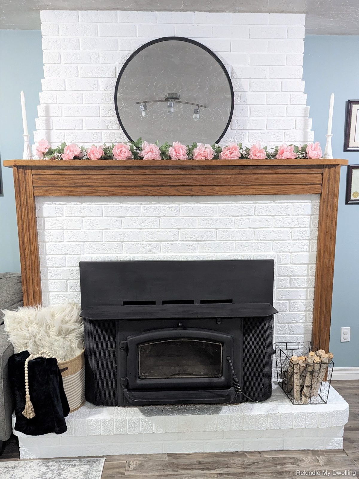 Simple spring mantel inspiration with flowers, candles and a basket.