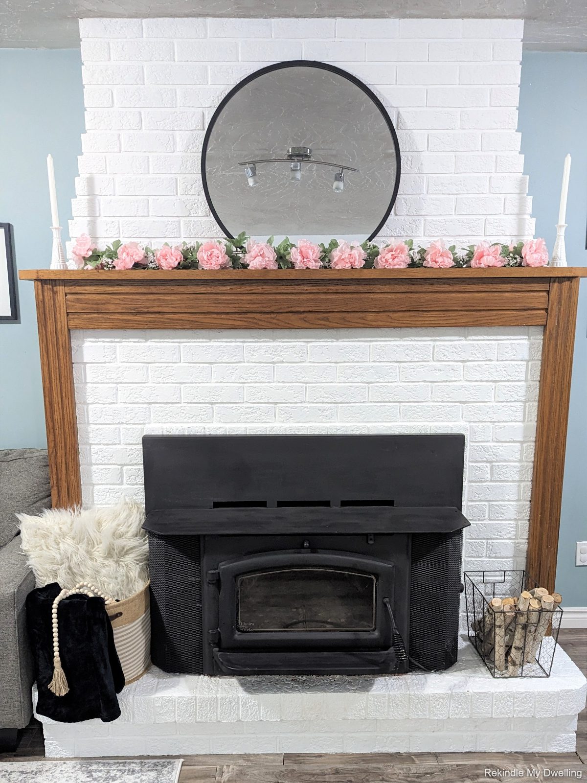 Simple spring mantel inspiration with flowers, candles and a basket.