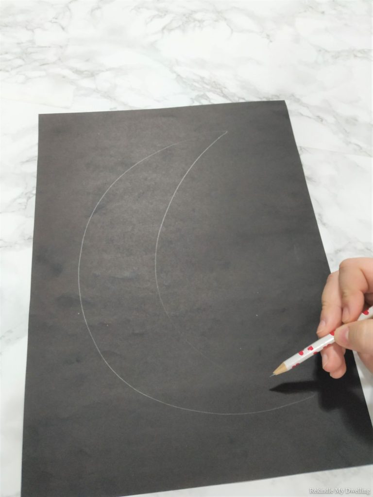 Outlining a moon shape.